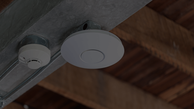A sleek, discreet white ceiling-mounted Wi-Fi access point, similar to Ubiquiti UniFi, installed in a home for seamless, whole-property Wi-Fi coverage.